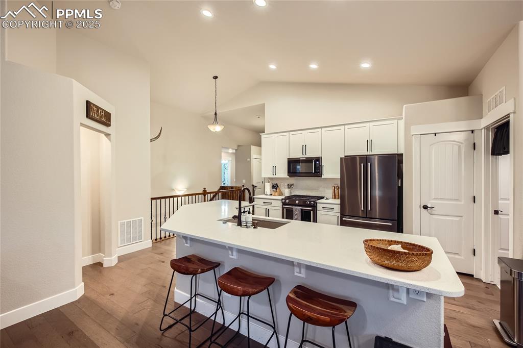 Image 8 of 37: Kitchen with freestanding refrigerator, gas range oven, a breakfast bar are