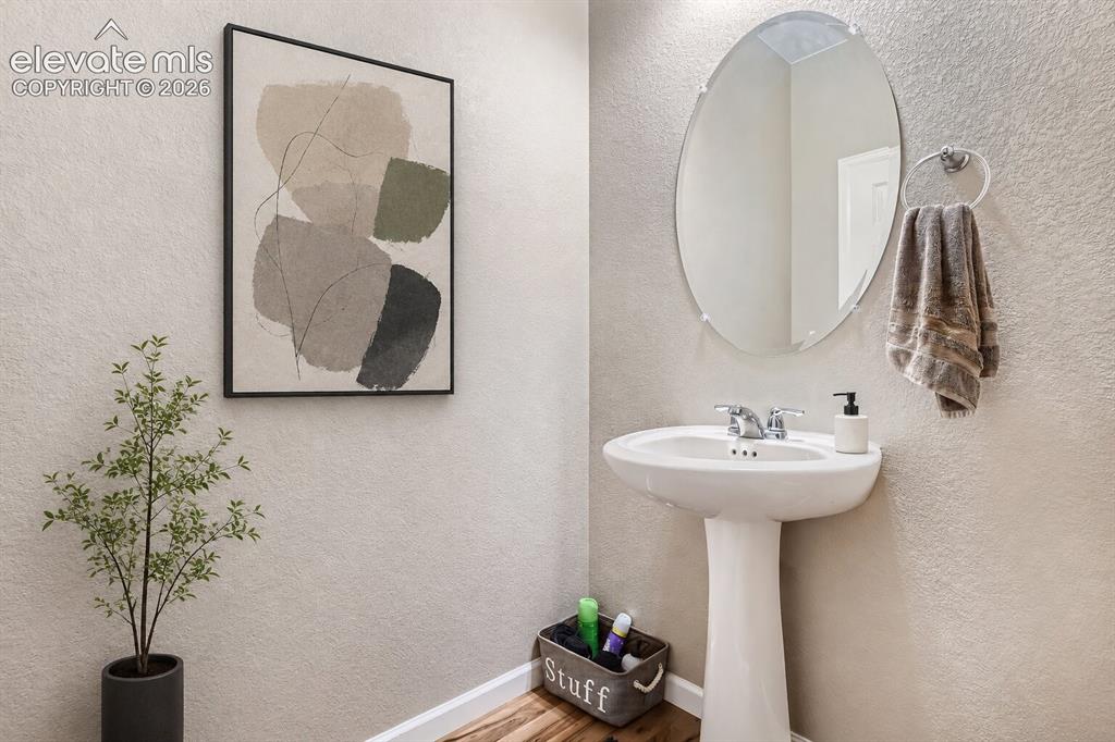Image 14 of 35: Pedestal sink with a polished chrome faucet, wall-mounted oval mirror, and