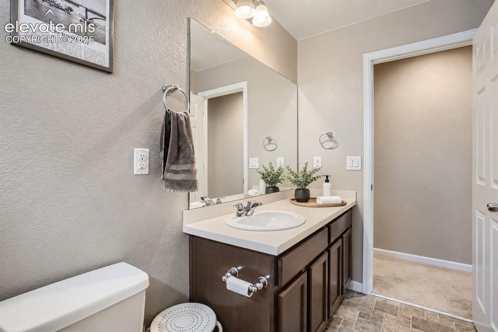 Image 8 of 35: Bathroom featuring a vanity with dark-finish cabinetry, a solid-surface cou