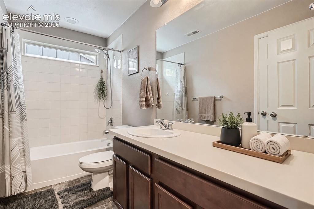 Image 9 of 35: Bathroom featuring a single-sink vanity with dark wood-finish cabinetry, a 