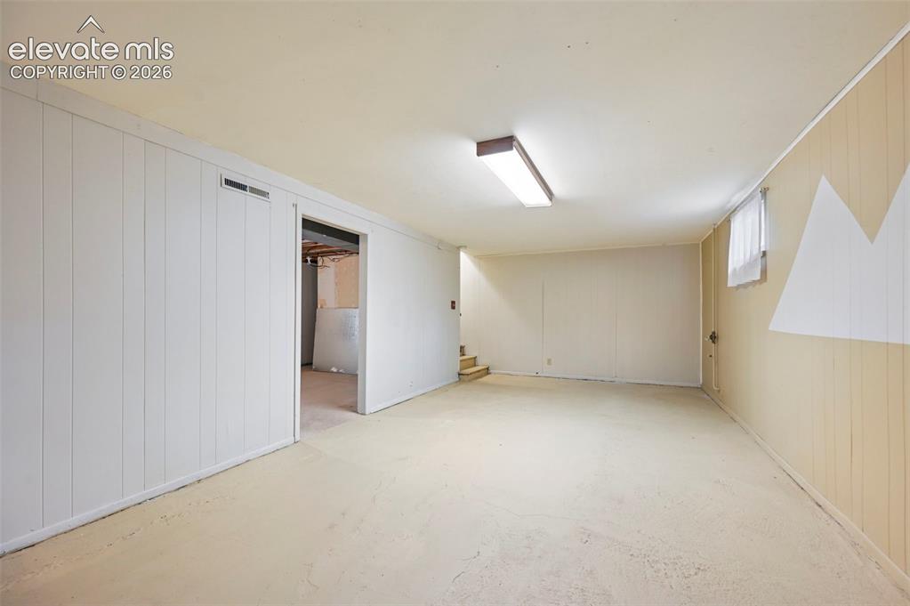 Image 12 of 35: Spacious room featuring light-colored flooring and walls, including white v
