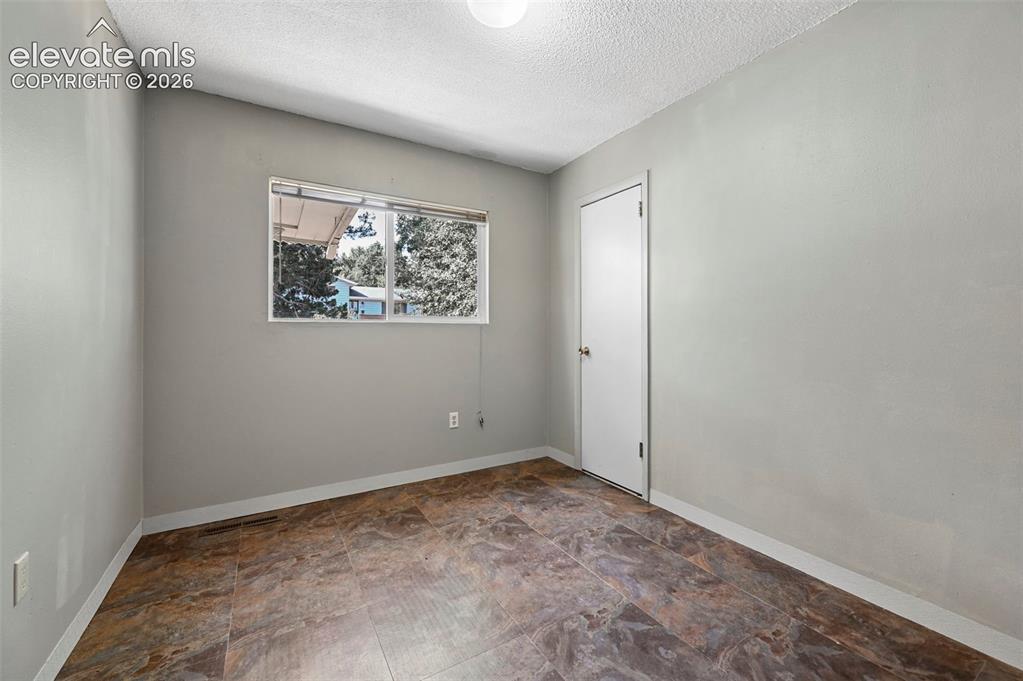 Image 17 of 32: Room featuring a light gray wall color, a single window, and multi-toned fl
