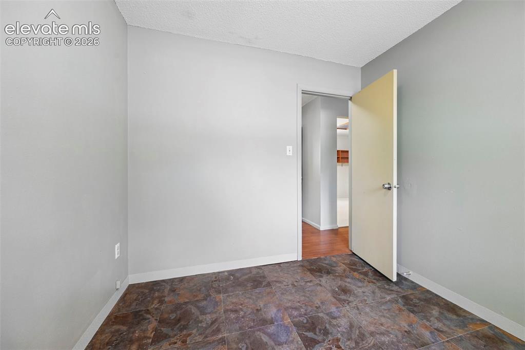 Image 23 of 32: Room featuring neutral gray walls and multi-toned tile flooring