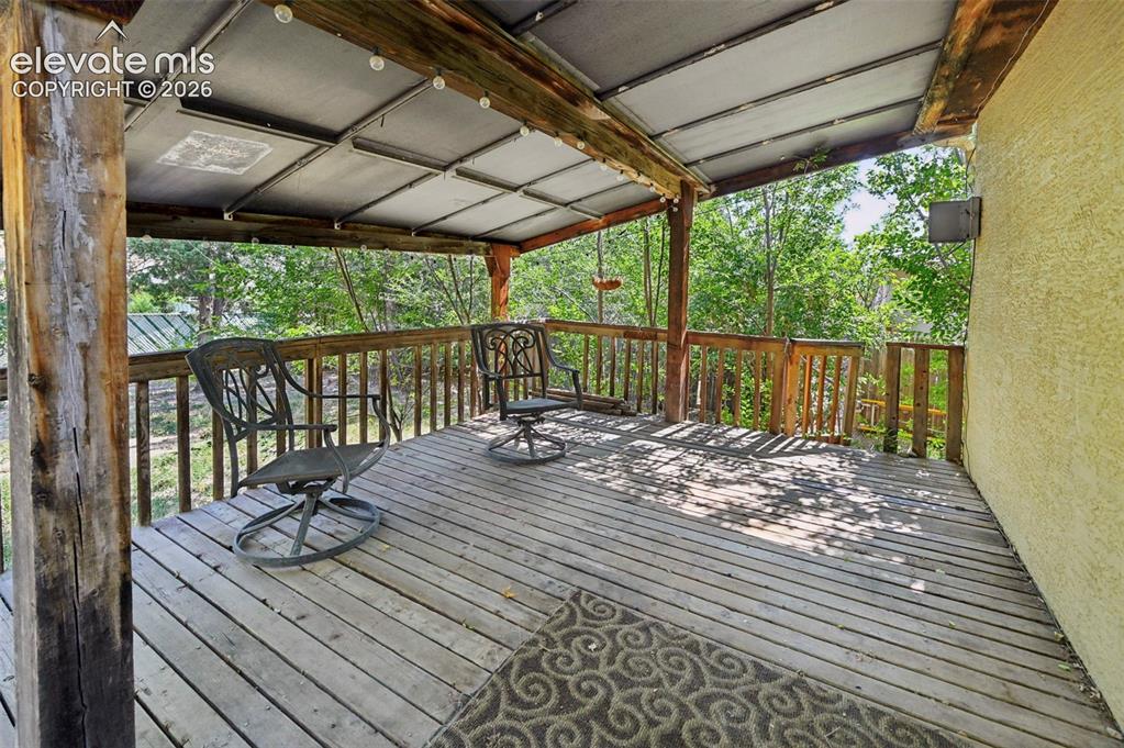 Image 26 of 32: Spacious outdoor deck featuring natural wood flooring and railing, exposed