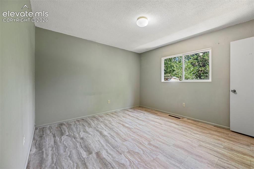 Image 29 of 32: Interior room featuring wood-finish flooring, a double-pane window, neutral