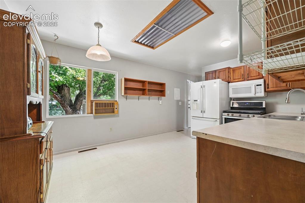 Image 6 of 32: Kitchen area with light-toned flooring and white walls