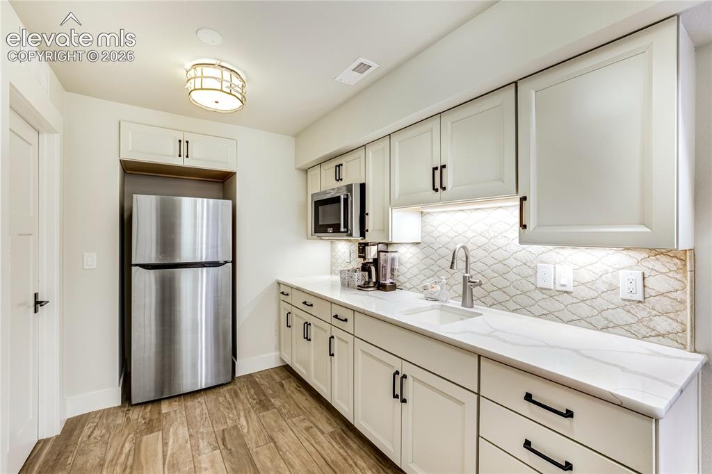 Image 38 of 50: A thoughtfully designed secondary kitchen area supporting multigenerational
