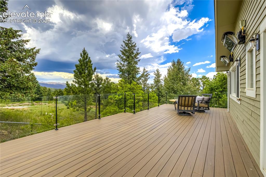 Image 45 of 50: Expansive outdoor living captures breathtaking city light, mountain, and su