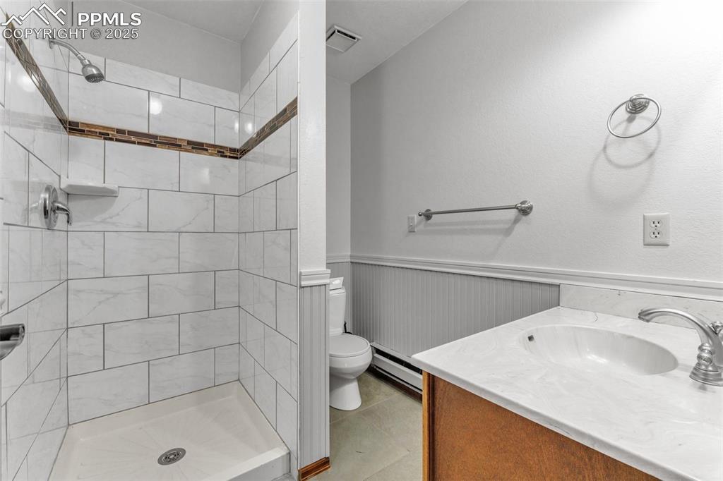 Image 15 of 43: Bath with toilet, tiled shower and vanity