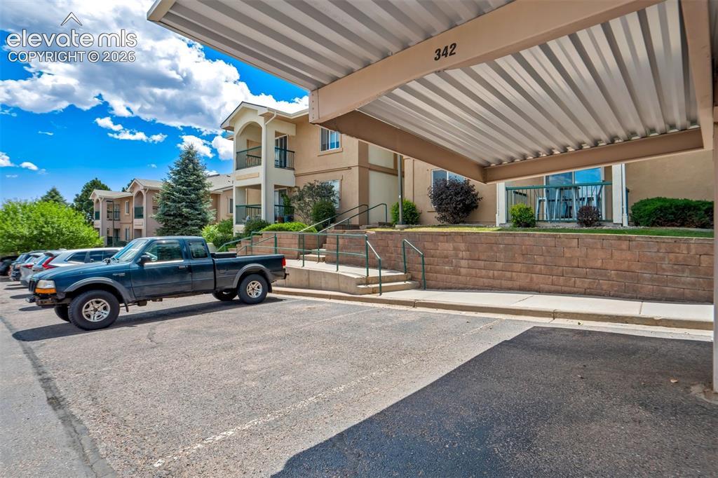 Image 3 of 50: Reserved spot under the carport with ample guest parking in front of buildi