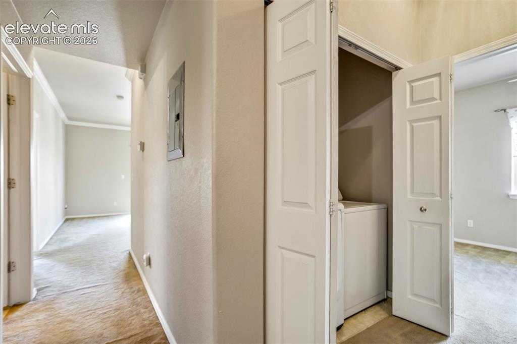 Image 36 of 50: Hallway with laundry and access to bedroom