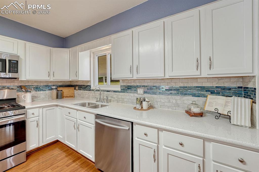 Image 11 of 42: Enjoy ample meal prep space with an elegant full height tile backsplash
