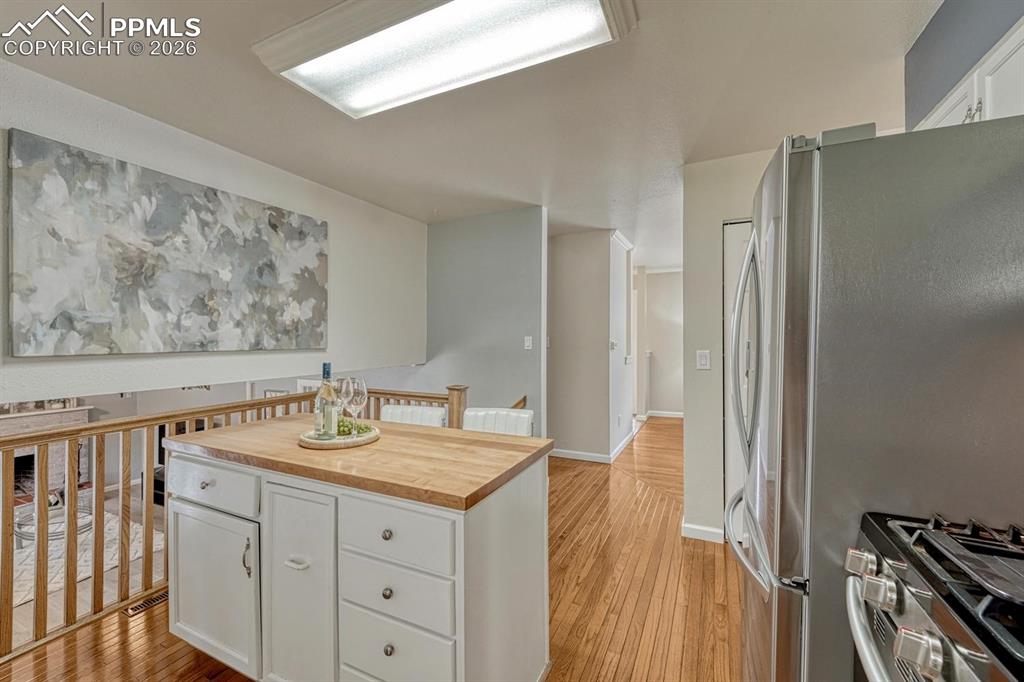 Image 12 of 42: With a large pantry and stunning white cabinetry, this kitchen perfectly bl