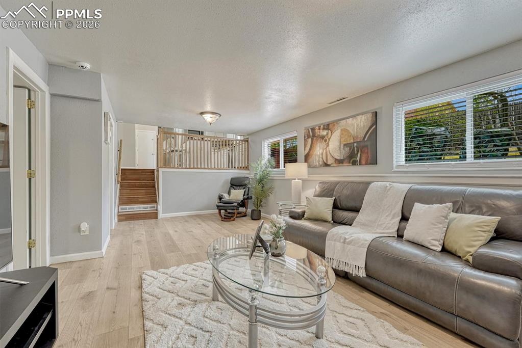 Image 13 of 42: Head down to the lower-level family room, a space featuring brand-new vinyl