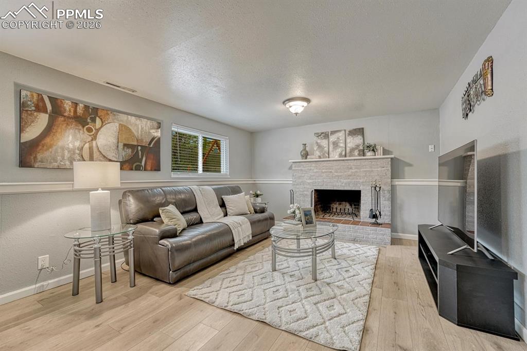 Image 14 of 42: Enjoy evenings curled up by the wood-burning brick fireplace. It is the ult