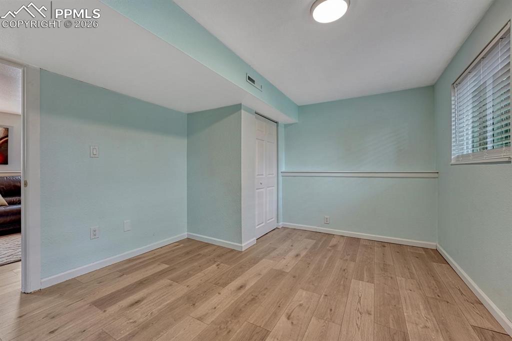 Image 18 of 42: With great natural light and new vinyl plank flooring, this lower-level bed