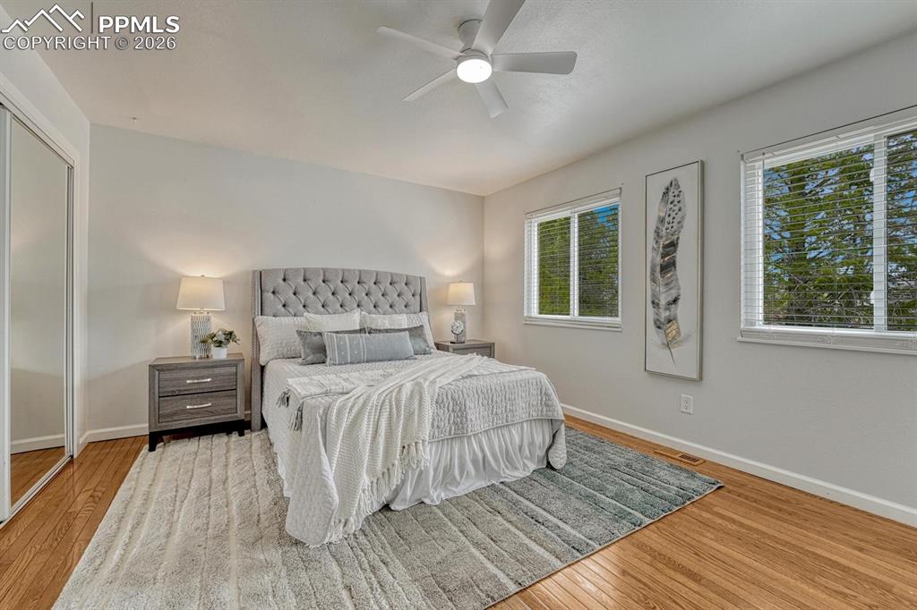 Image 22 of 42: Retreat to the upper-level primary bedroom, featuring warm hardwood floors,