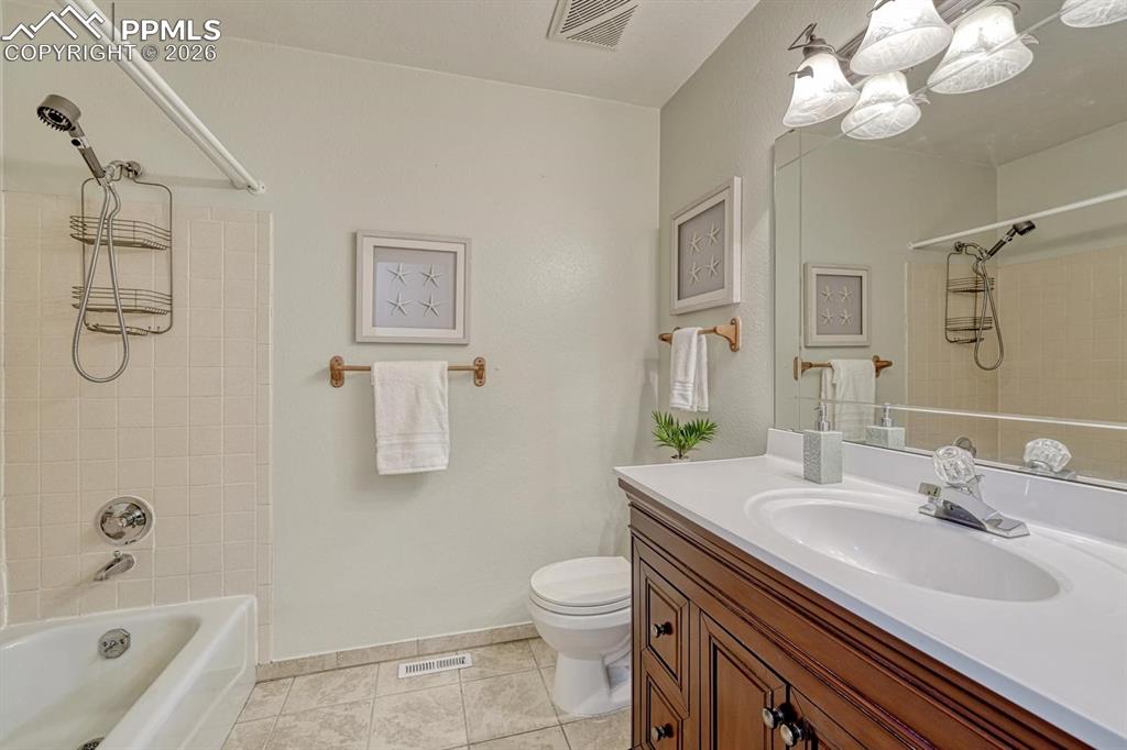 Image 29 of 42: The upper level is completed by a full bathroom with a large vanity and a s