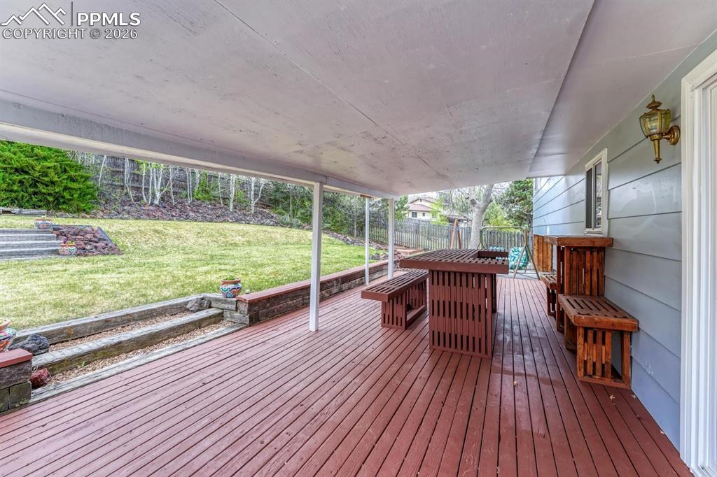 Image 32 of 42: Step outside to your covered wood deck, the ultimate spot for summer barbec