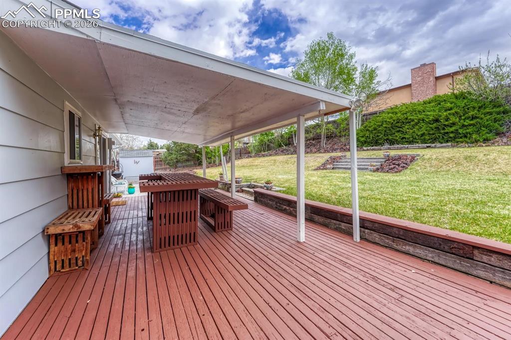 Image 33 of 42: The deck features fantastic built-in wooden seating and a table area, makin