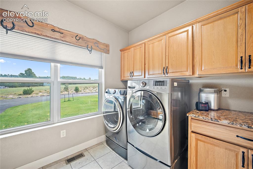 Image 12 of 42: Laundry/mud room with tons of cabinet space and large window for natural li