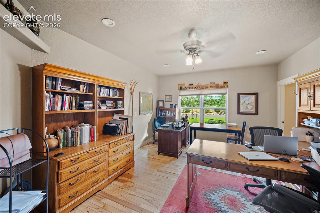 Image 17 of 42: Spacious office with hickory flooring. This flexible space could also be us
