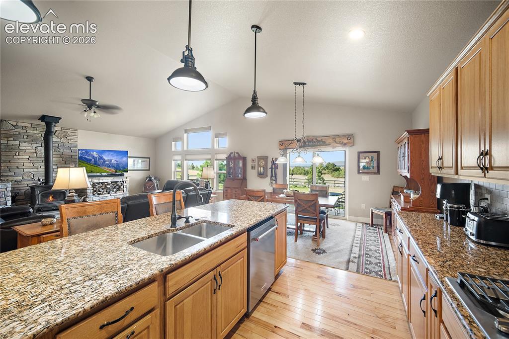 Image 5 of 42: Open concept kitchen, dining, living room. Gorgeous hickory flooring and va