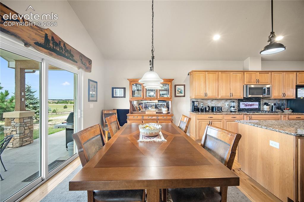 Image 7 of 42: Dining space walks out to covered patio and sweeping views of Pikes Peak an