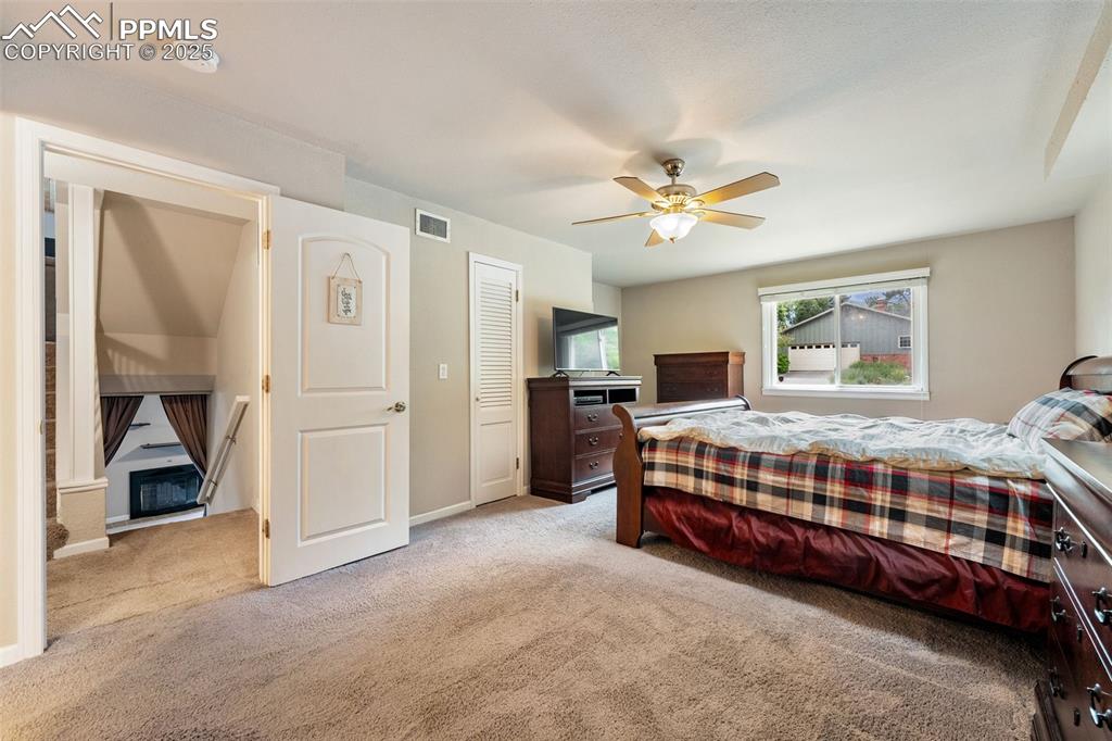 Image 11 of 29: Carpeted bedroom with a ceiling fan and baseboards
