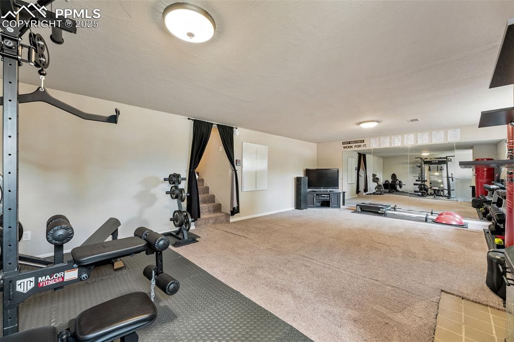 Image 16 of 29: Workout area featuring carpet floors and baseboards