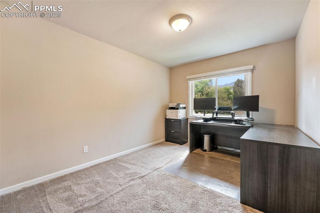 Image 17 of 29: Home office with light colored carpet and baseboards