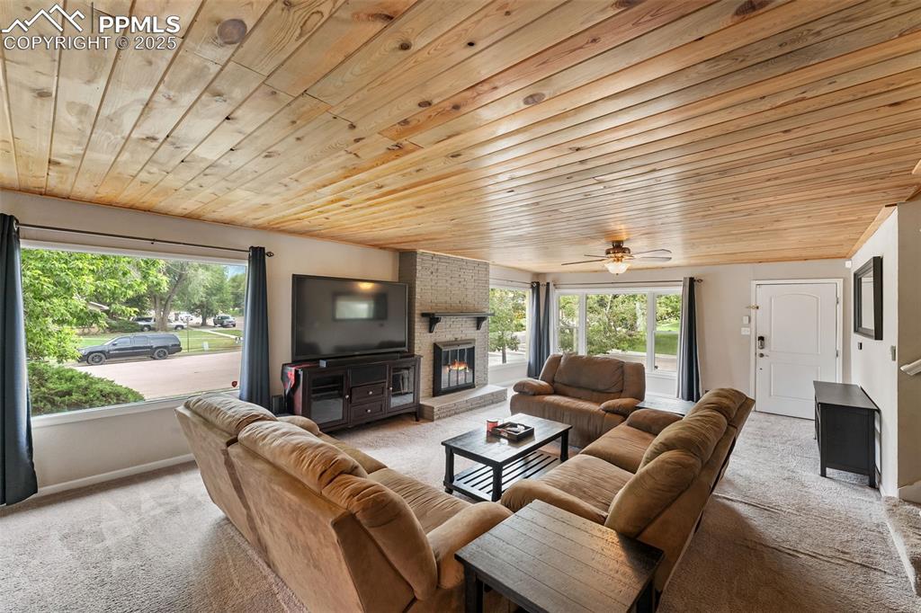 Image 2 of 29: Living area with light carpet, healthy amount of natural light, wooden ceil