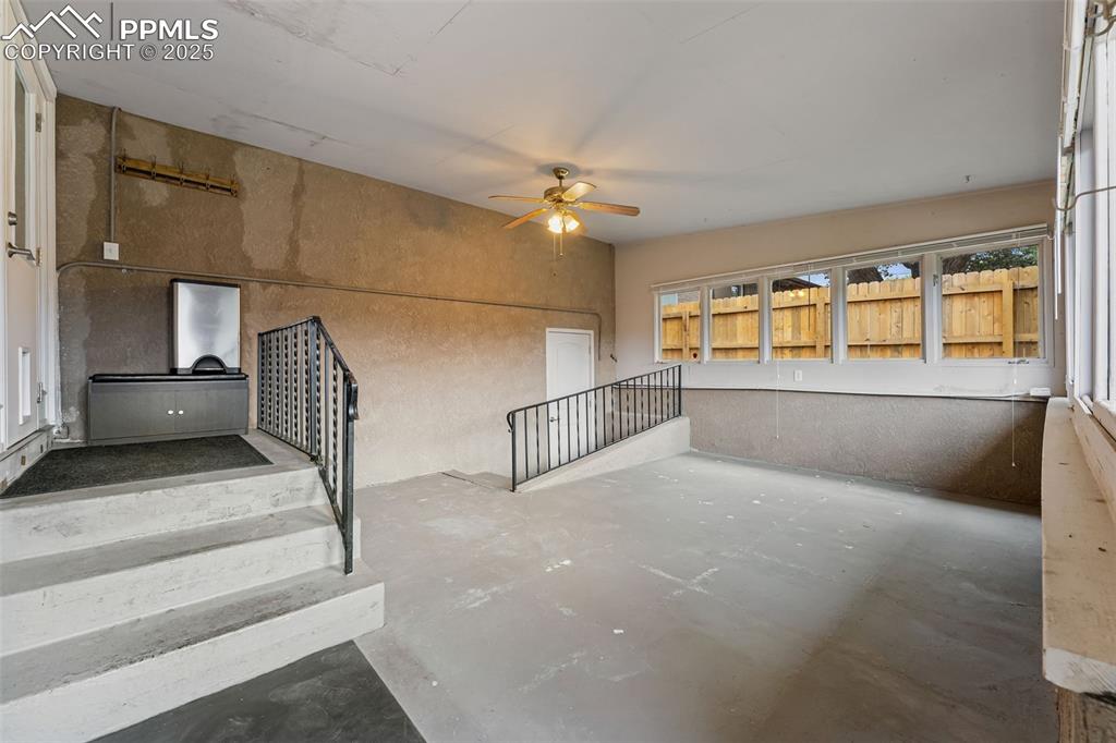 Image 21 of 29: Stairs with concrete floors and ceiling fan