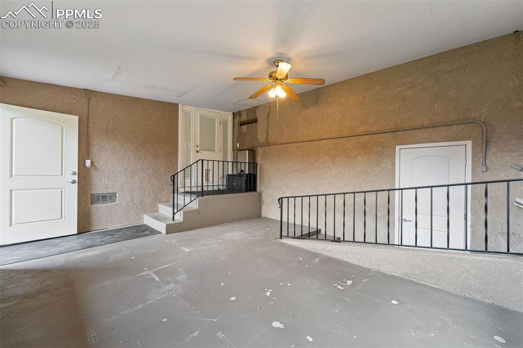 Image 22 of 29: Empty room featuring a textured wall, unfinished concrete floors, a ceiling