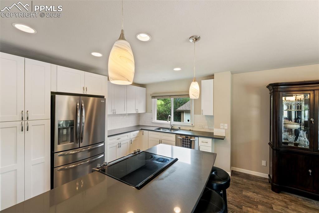 Image 4 of 29: Kitchen featuring stainless steel fridge with ice dispenser, dark counterto