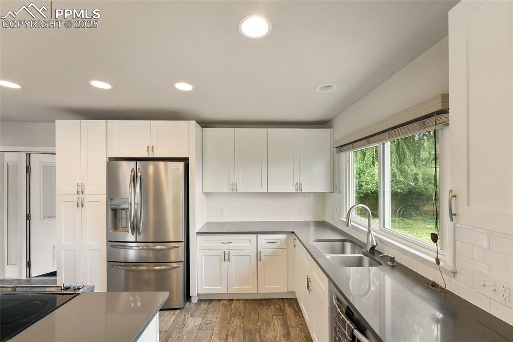 Image 6 of 29: Kitchen with stainless steel refrigerator with ice dispenser, white cabinet