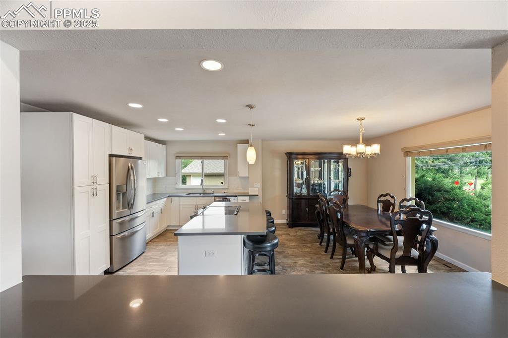 Image 7 of 29: Kitchen featuring stainless steel fridge, light wood finished floors, white