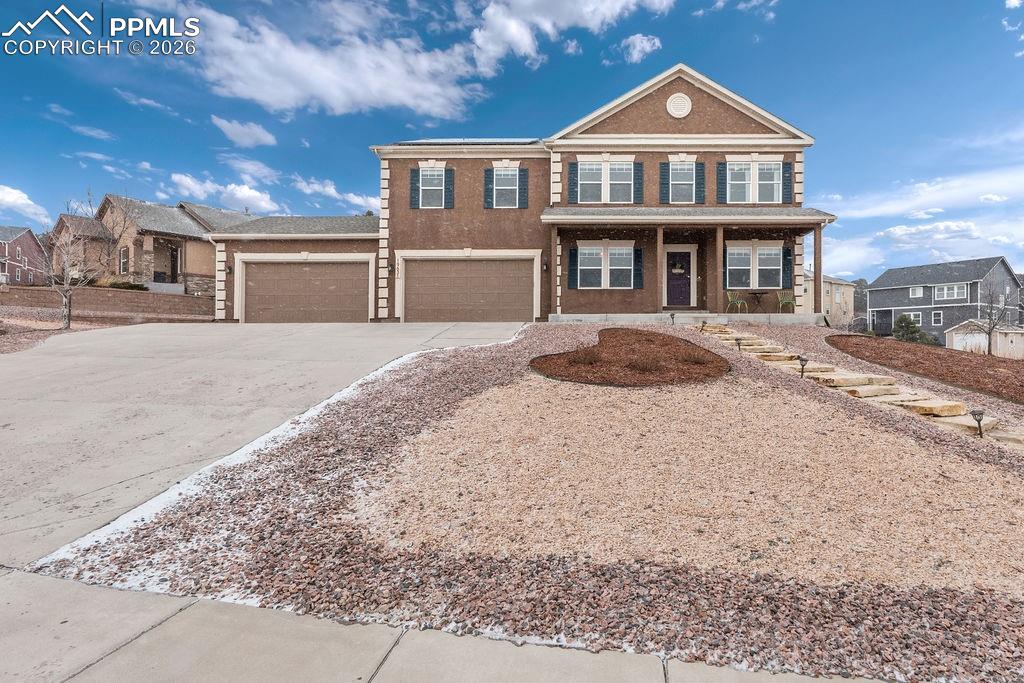 Image 1 of 43: View of front of home featuring driveway, covered porch, an attached garage