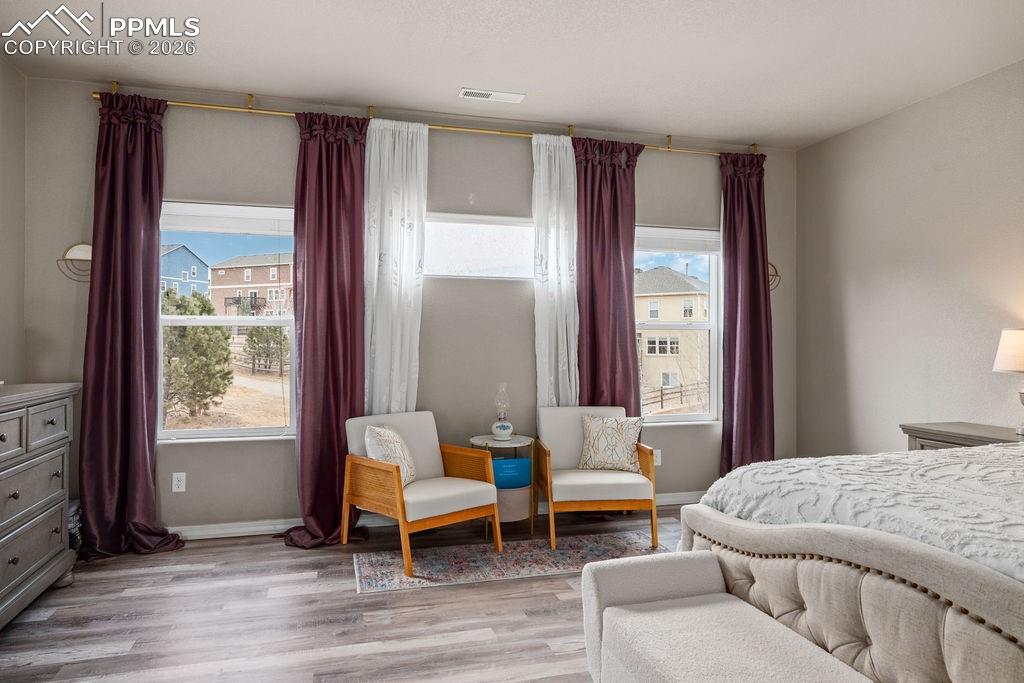 Image 25 of 43: Upper floor primary bedroom featuring light wood-style flooring and baseboa