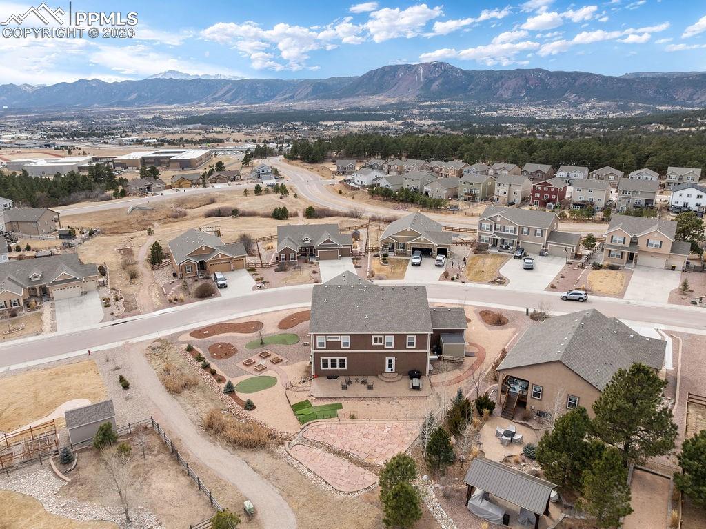 Image 42 of 43: Aerial view of property and surrounding area featuring a mountainous backgr
