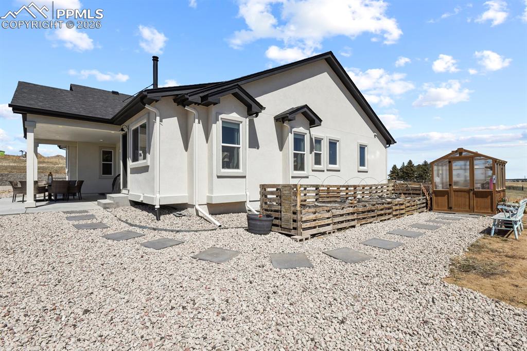 Image 40 of 50: Raised garden beds and greenhouse