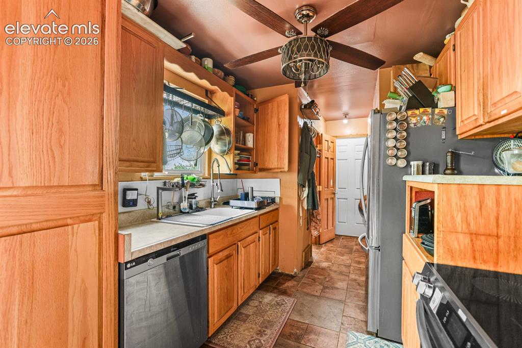 Image 10 of 33: Kitchen featuring wood-finish cabinetry, solid surface countertops, a stain
