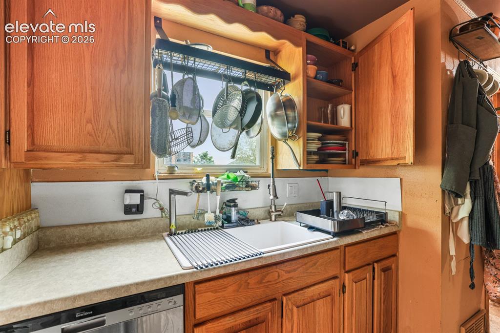 Image 11 of 33: Kitchen workstation featuring light wood cabinetry, a white single-basin si