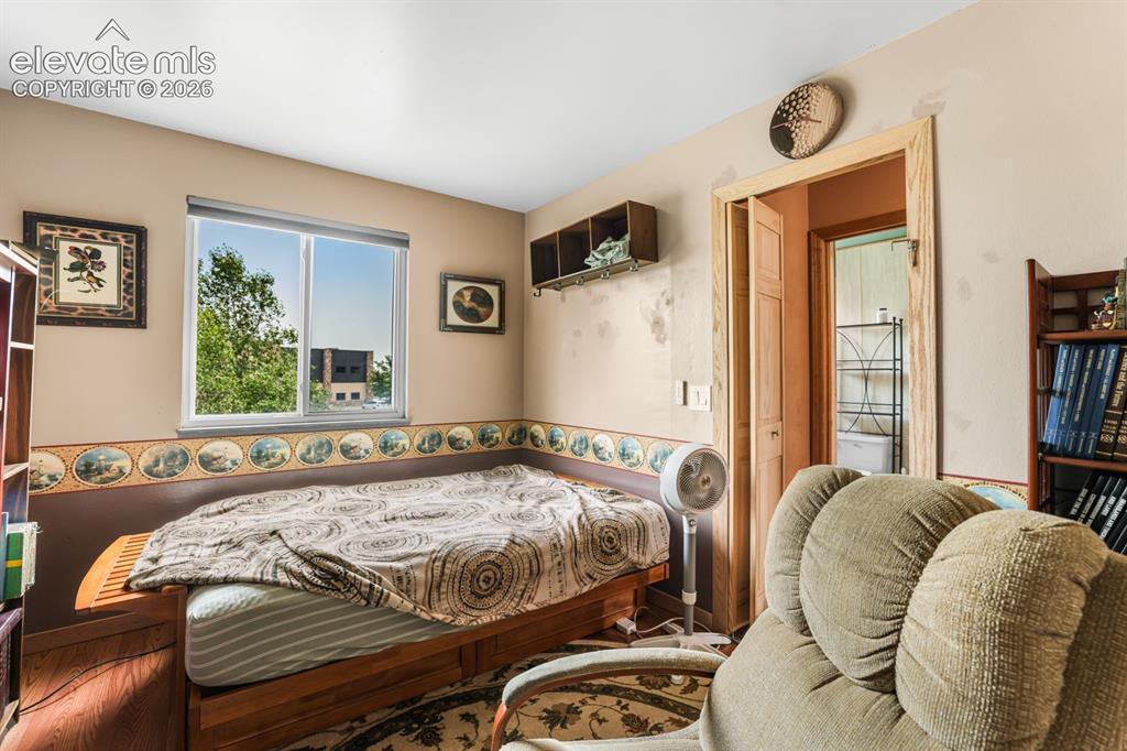 Image 16 of 33: Room featuring a single window, two-tone walls with a decorative border, a