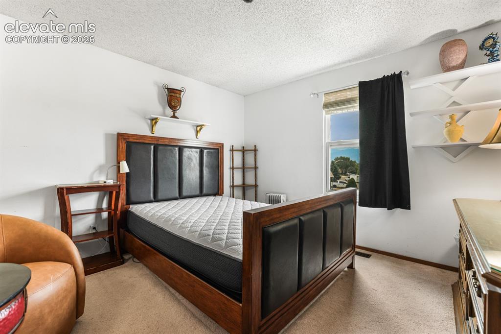 Image 19 of 33: Bedroom featuring carpet flooring, white walls, and a window with blinds