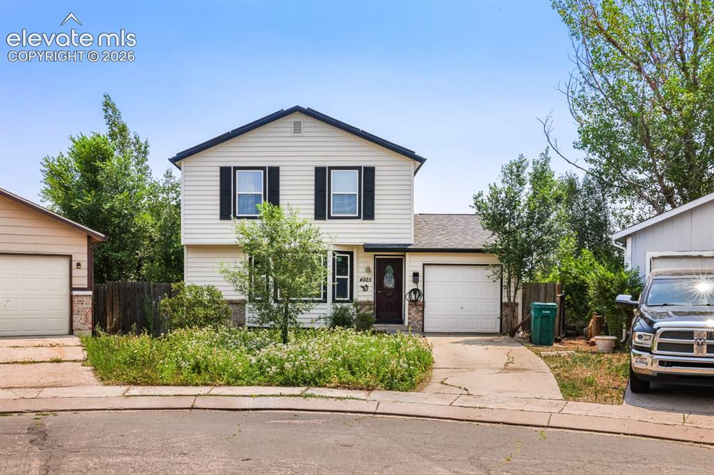 Image 2 of 33: Two-story residence featuring light-colored siding with dark shutters, a da