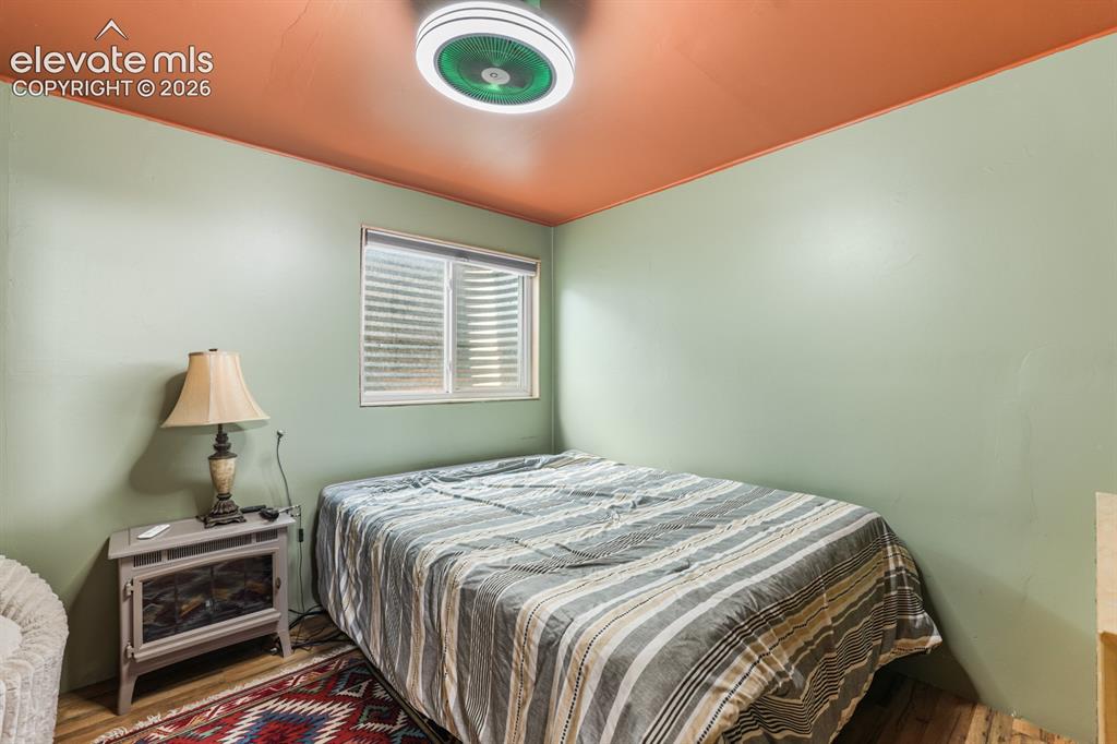 Image 25 of 33: Interior room with wood-finish flooring and light green walls