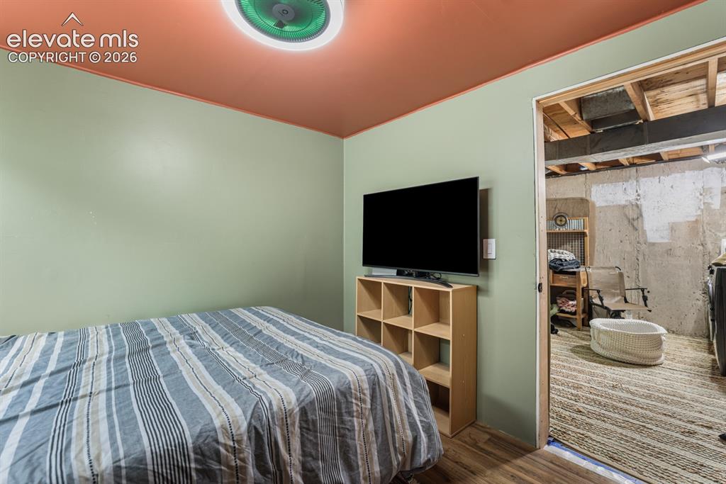 Image 26 of 33: Interior room featuring wood-finish flooring, light green walls, and a warm