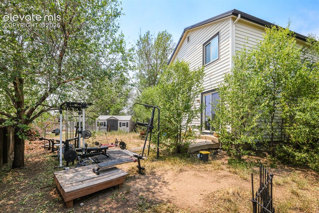 Image 32 of 33: Rear exterior featuring light-colored siding and dark trim