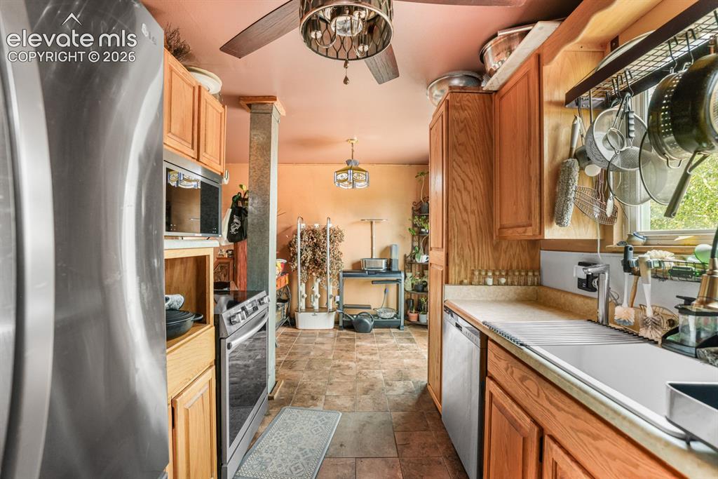 Image 9 of 33: Kitchen featuring wood cabinetry, stainless steel appliances, and a ceiling